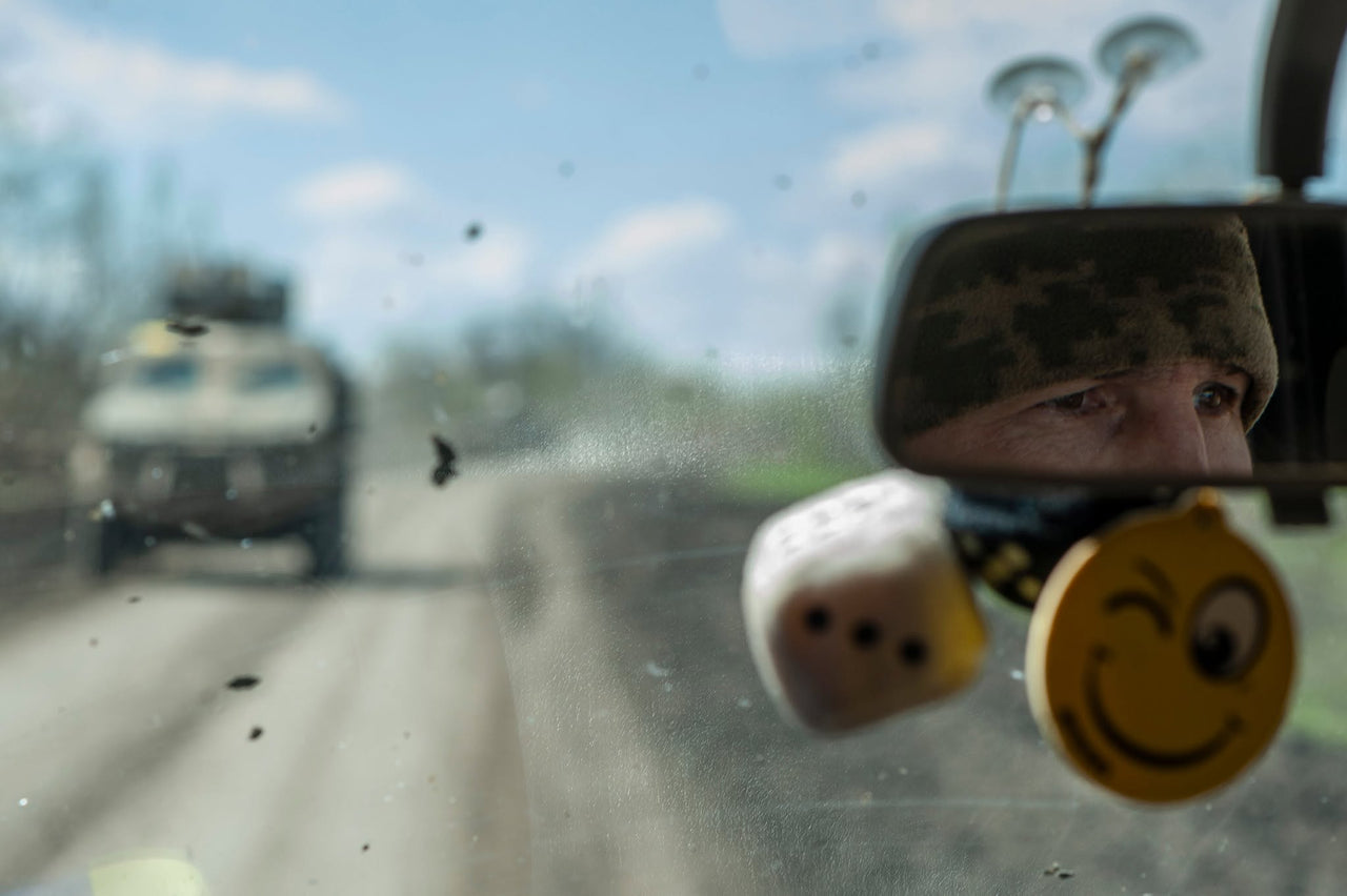 A driver reflected in a vehicle mirror.