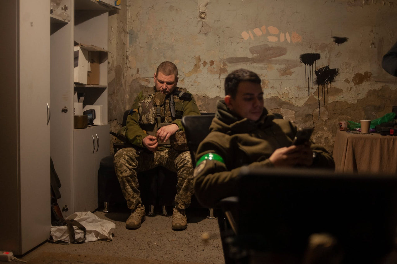 Servicemembers resting indoors.