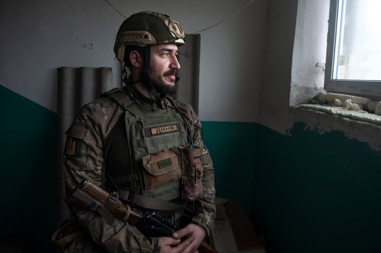 A servicemember resting near a window.